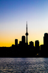 Obraz premium CN Tower and Toronto skyline with lake reflection during sunset or golden hour, city light after sunset