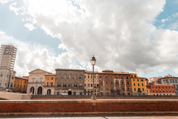 Obraz premium Beautiful vintage European town with old houses on a bridge road along the river in Pisa, Italy
