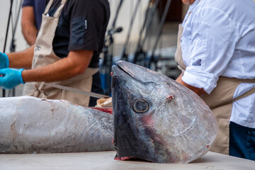 Die Kunst des “Ronqueo” hier wird ein 100 Kilogramm schwerer Thunfisch zerlegt. Puerto de la Cruz, Teneriffa, eine öffentliche Veranstaltung am Hafen.  - obrazy, fototapety, plakaty