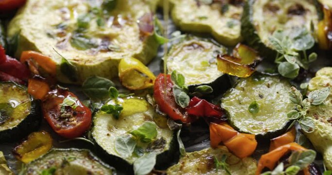 Pouring fresh olive oil over grilled vegetables, close up view