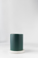 Green ceramic cup on a white marble saucer, Green mug