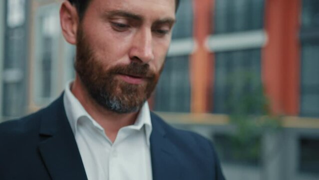 Inspired successful adult caucasian businessman bearded wealthy man stand in city hold smartphone use mobile phone outdoor work online search information texting messages distant chat cell connection