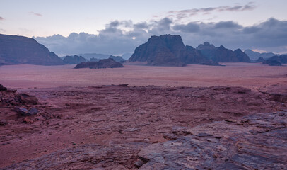 Purple orange Mars like landscape in Jordan Wadi Rum desert, mountains background, overcast morning. This location was used as set for many science fiction movies