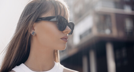 Portrait of beautiful stylish brunette woman in black sunglasses in outdoor. Close up photo.