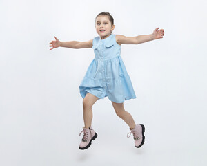 little black-haired girl in a dress and high boots jumps in the studio on a white background
