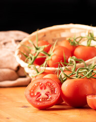Tomatoes, beautiful details of fresh red tomatoes on branches over rustic wood, selective focus.