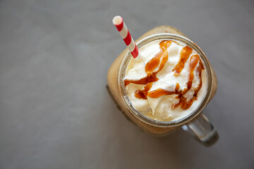  Homemade Caramel Iced Latte with Whipped Cream in a Glass Jar, top view. Flat lay, overhead, from...