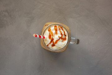  Homemade Caramel Iced Latte with Whipped Cream in a Glass Jar, top view. Flat lay, overhead, from...