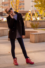 woman walking on the street in autumn and using mobile phone