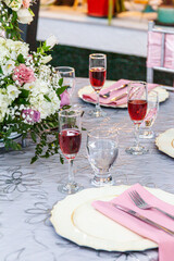 Mesa con arreglos de matrimonio, arreglos para la cena y copas de vino