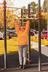 senior aged woman doing exercises on the sports ground outdoor