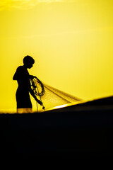 Silhouette of a fisherman at sunset