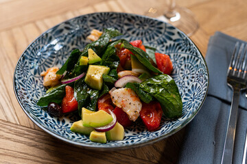salad with avocado and chicken on a plate in a restaurant on the table