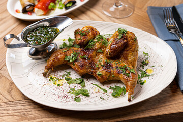 tobacco chicken on a plate in a restaurant on the table