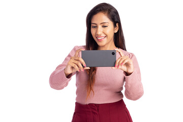 Cheerful young woman watching video in mobile phone isolated on white.