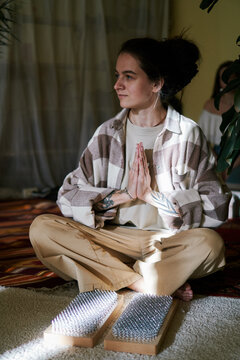 A Young Girl Sits With Folded Hands In Namaste