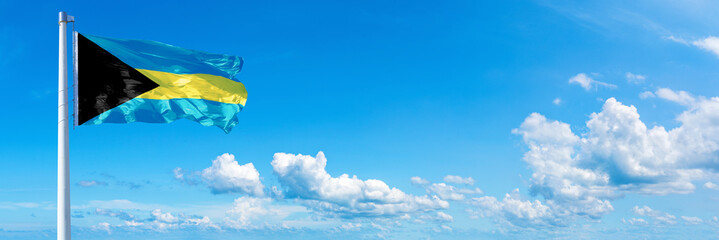 The Bahamas flag waving on a blue sky in beautiful clouds - Horizontal banner