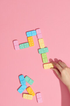 Female hand puts domino bone in a line, top view