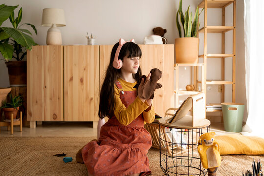 Cute girl making puppets for her homework at living room
