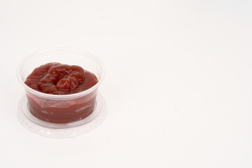 condiment cup with ketchup isolated on white 
