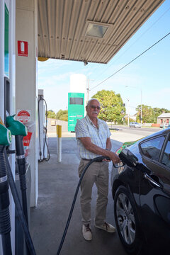 Senior man refuelling car at petrol station