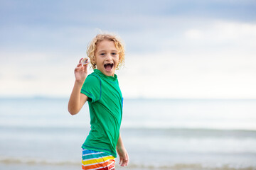 Kids play on tropical beach. Sand and water toy.