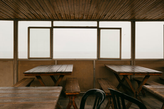 stark establishment with wooden tables and benches with big window