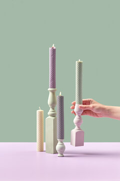 Candles with holders in woman's hand.