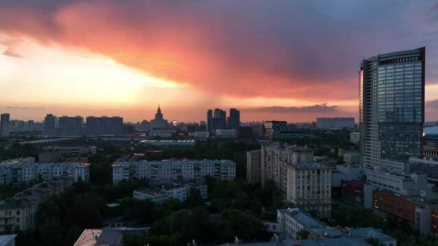 Epic aerial view of a beautiful sunset over Moscow streets and rooftops. Beautiful buildings made of glass and concrete. The scarlet sky and the last rays of the sun over the metropolis.