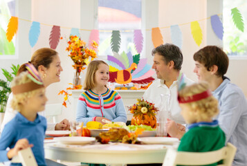 Family with kids at Thanksgiving dinner. Turkey.