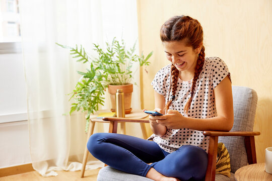 Merry young woman using cellphone