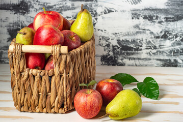 pears and apples in a wicker basket. New crop with fresh fruits.
