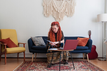 Female freelancer with dreadlocks reading paper