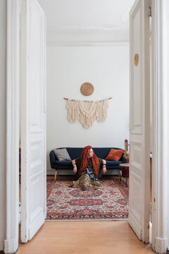 Relaxed hippie sitting on floor near couch