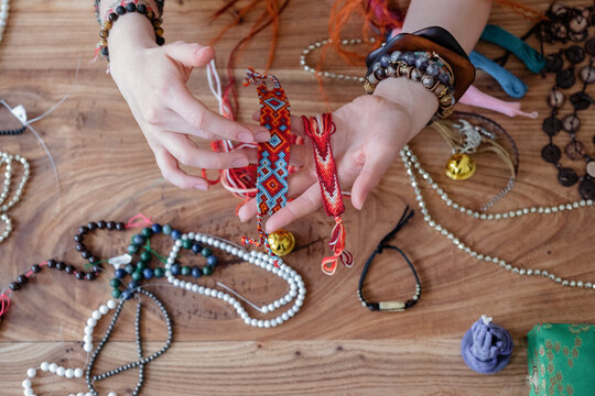 Crop craftswoman examining friendship bracelets