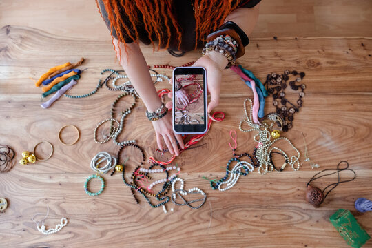 Crop craftswoman shooting handmade bracelets