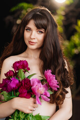 Naklejka premium an beautiful woman with long hair and bare shoulders and a bouquet of peonies
