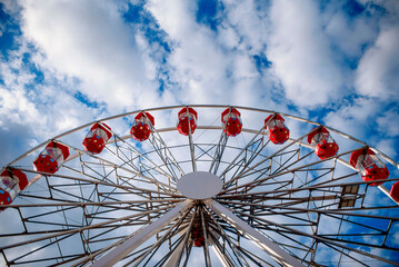 Red giant Ferris wheel against the blue sky. Entertaining attractions in Zielona Gora in Poland at the wine picking festival.