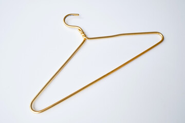 Gold clothes hanger on a light background. Smart consumption or sales concept
