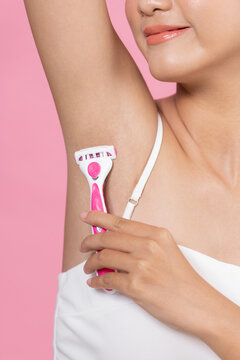 Young girl, raising her hands shaves her armpit, hair removal