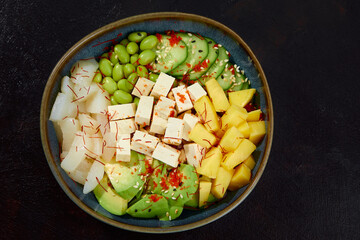 Top view on poke salad with tuna and green vegetable in the bowls on gray background. Copy space.