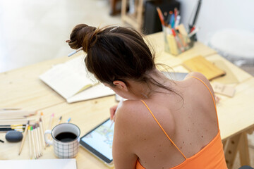 Female illustrator drawing on tablet at desk 