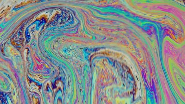 Fluid soap bubble psychedelic colorful abstract art. Surreal patterns with rainbows and waves of color in motion.