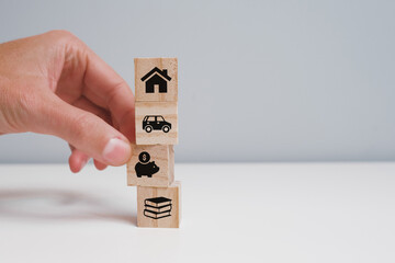 Fototapeta na wymiar A man's hand removing a wooden block with the symbol of savings. Savings concept