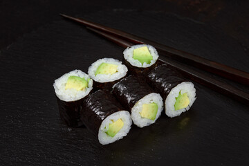 Sushi Maki rolls cucumber. Fresh hosomaki pieces with rice and nori. Close Up of delicious japanese food with sushi roll.