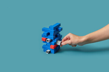 Block tower with dollars taken by female hand.