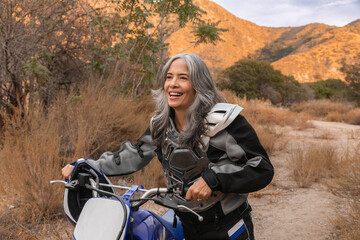 Mature woman happy outdoors on a dirtbike