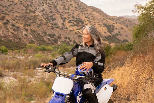 Mature woman smiling outdoors on a bike