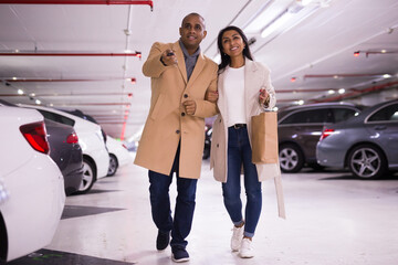 Elegant married couple in underground parking of a hypermarket