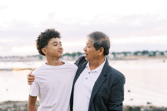 asian grandfather with his teenage grandson at the beach
